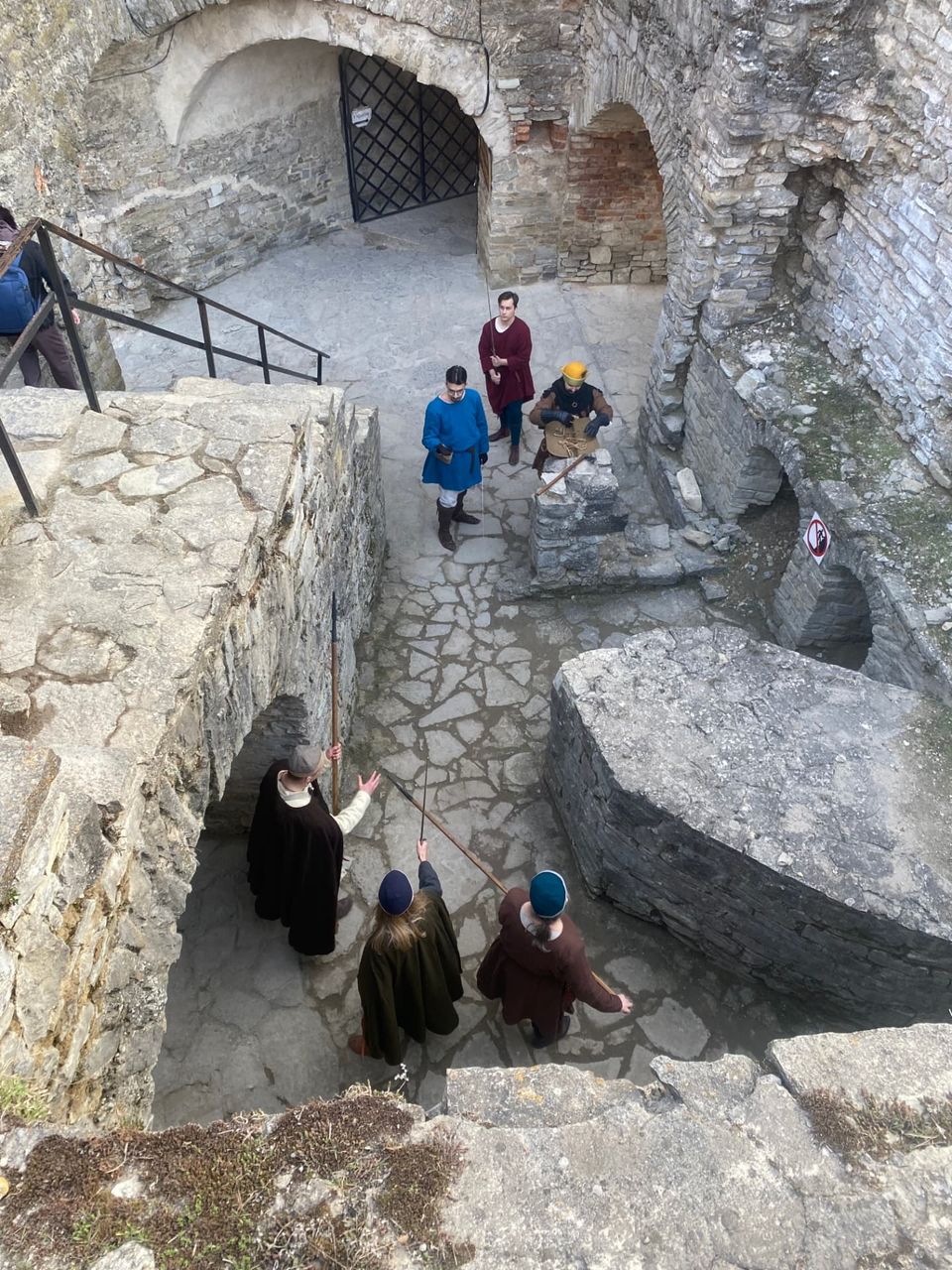 Participants in medieval clothing in a stone castle courtyard