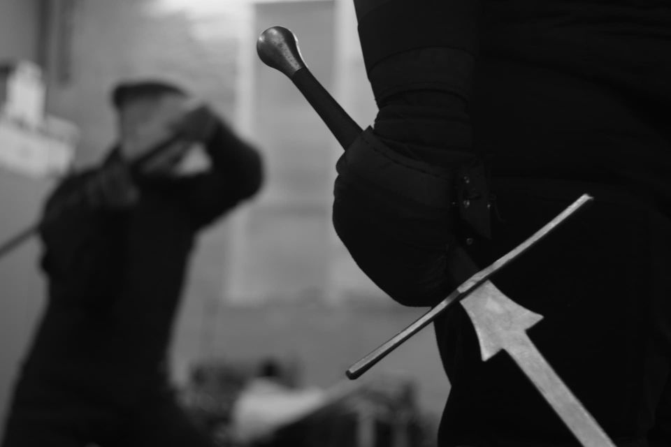 Longsword held in guard during indoor HEMA training