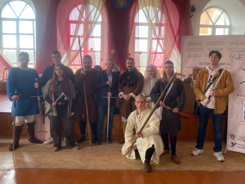 Group photo of participants with swords and spears after Atira Ruthenia's lecture at Kamianets-Podilskyi Ivan Ohiienko National University